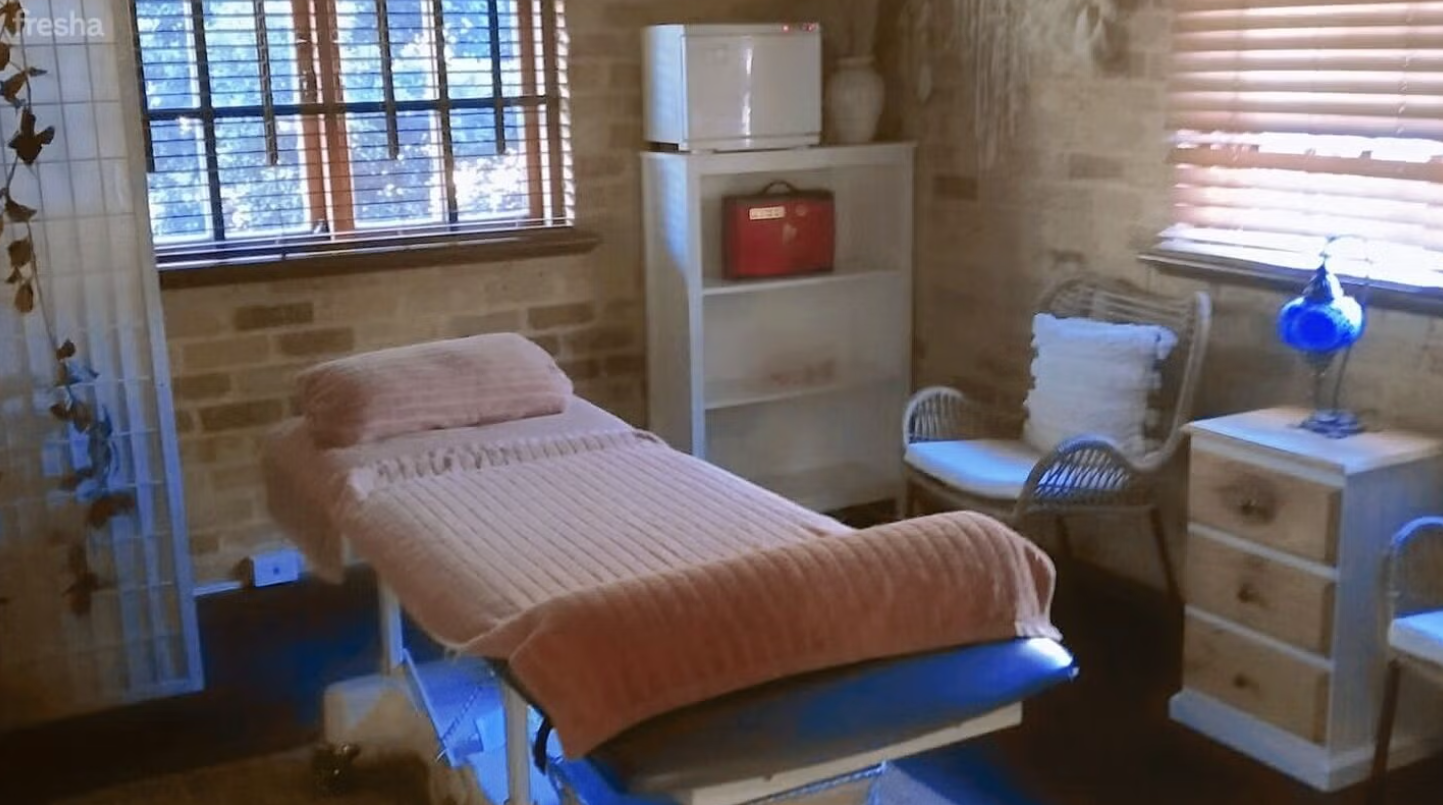 Treatment room with massage table and exposed brick walls